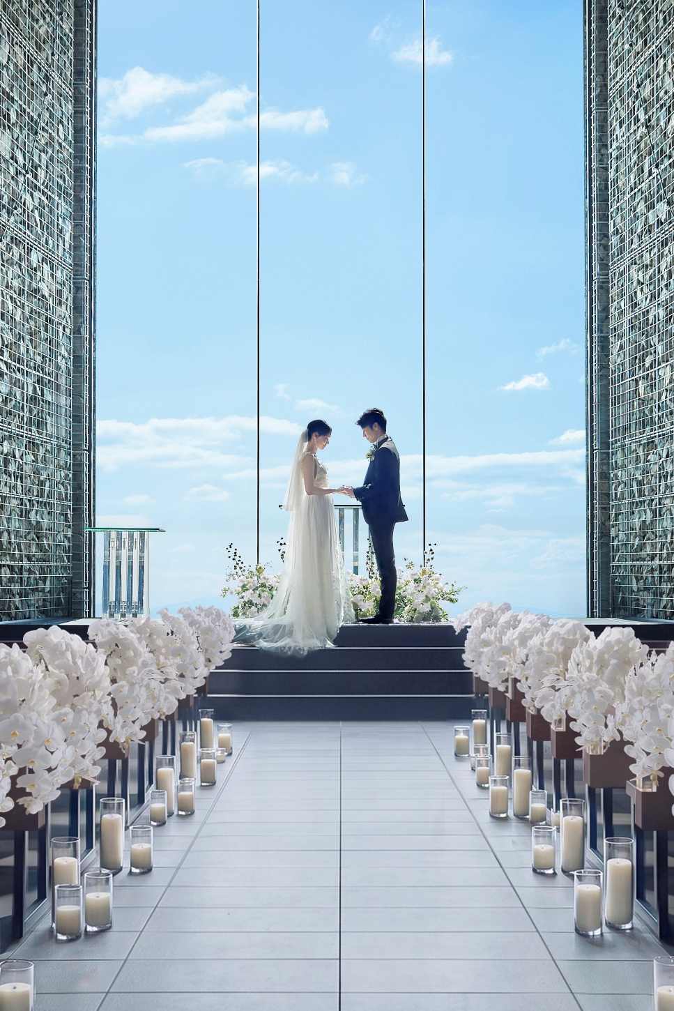 神戸の青空に向かって開かれた天空の教会で、手を取り合い誓いを交わす新郎新婦