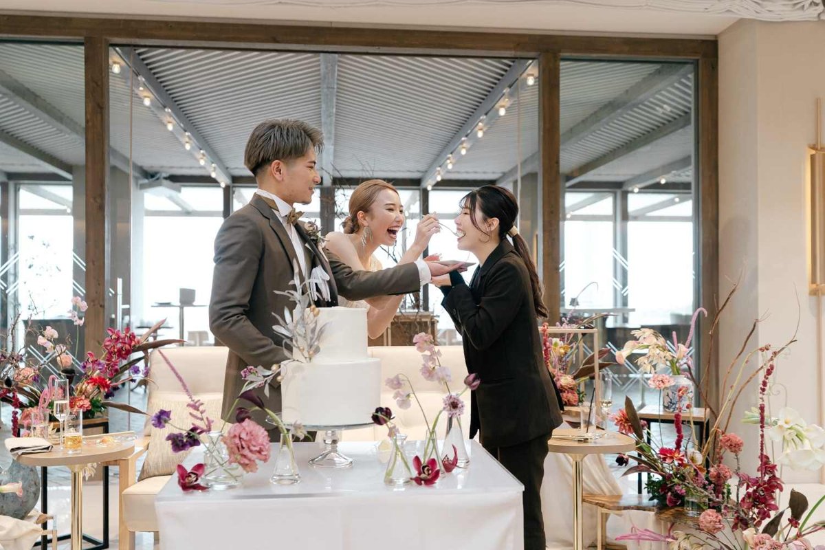 ケーキのファーストバイトをプランナーと楽しむ新郎新婦